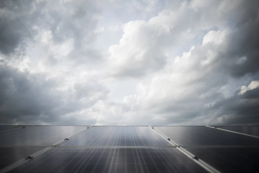 imagem mostra céu nublado e abaixo painéis solares gerando energia solar no inverno